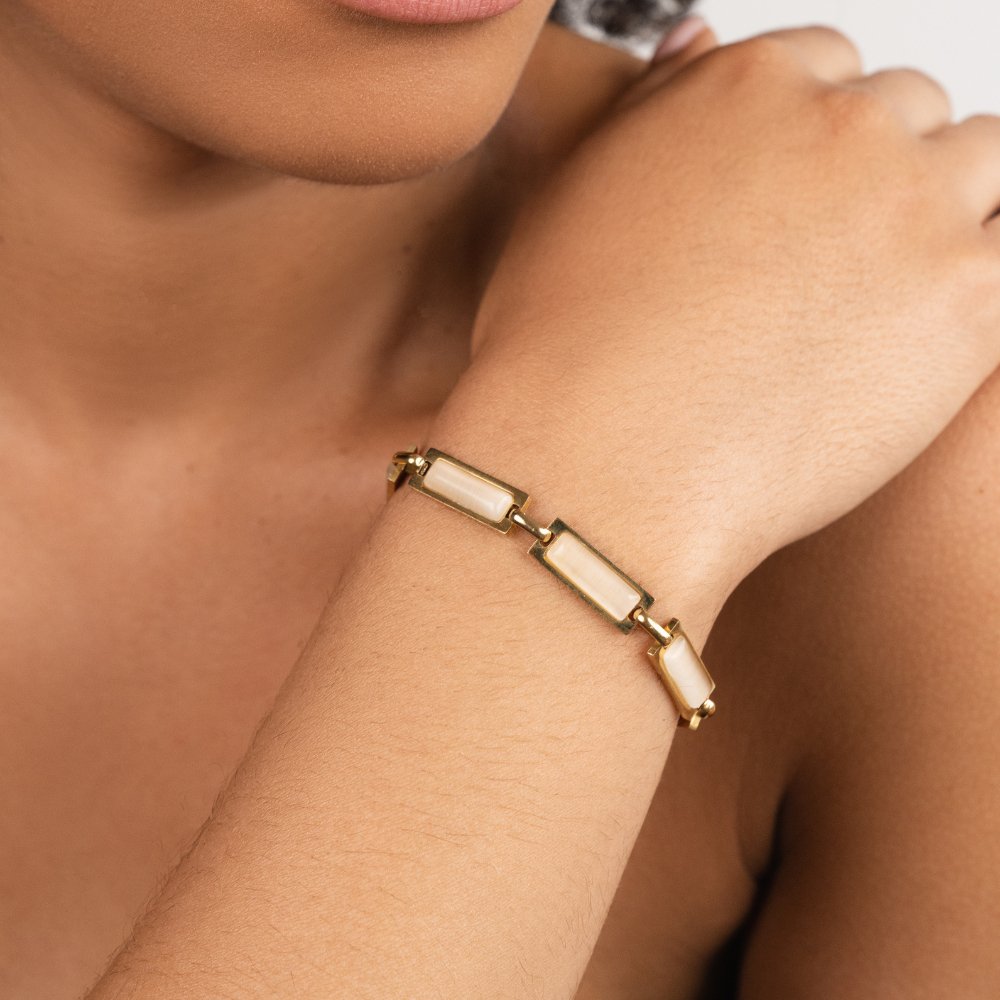 Opal Gold Baguette Bracelet, worn on a wrist, with gold links and pale rectangular stones