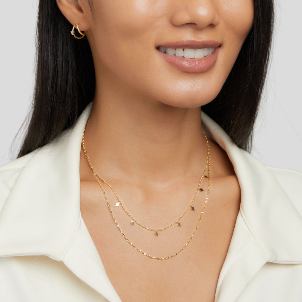 Phoenix Layered Necklace, worn layered on a smiling model in a white collared top