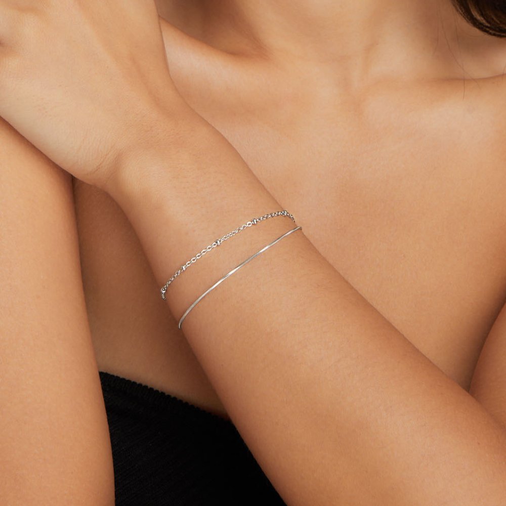 Pia Silver Layered Bracelet, worn on a wrist with a thin silver chain and a bangle