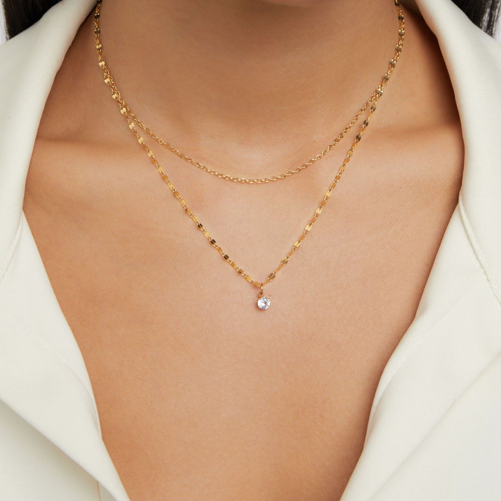 Piya Crystal Layered Necklace, worn on a neck over a white collared shirt, round clear stone pendant