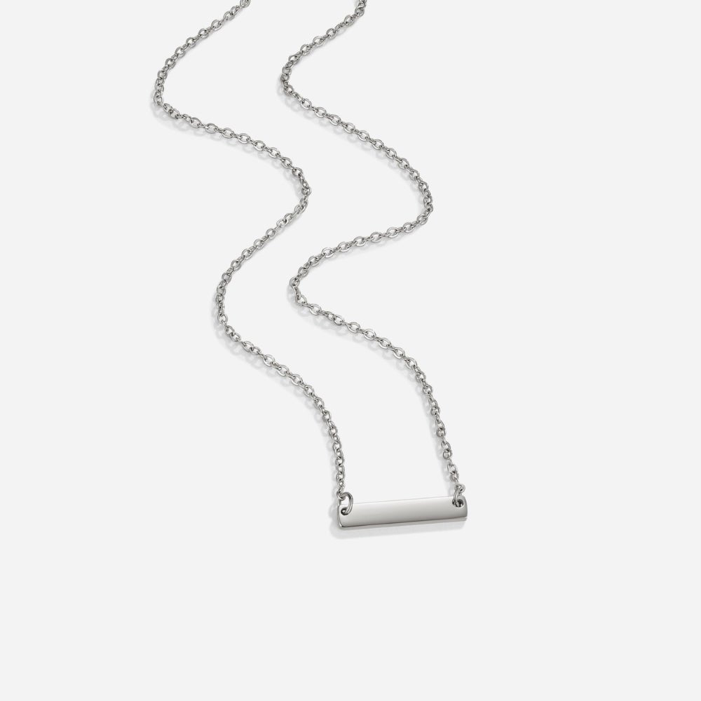 Rina Silver Bar Necklace, silver chain necklace laid out on white with a polished bar pendant