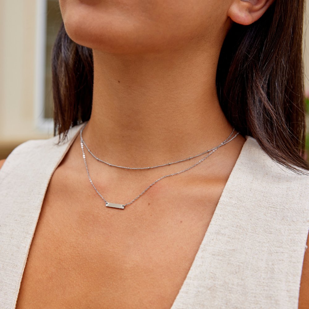 Rina Silver Bar Necklace, worn on a neck with a beige linen top, two silver chains