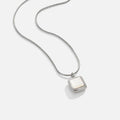 Riva Moonstone Pendant Necklace, laid flat on white, silver chain with square white pendant