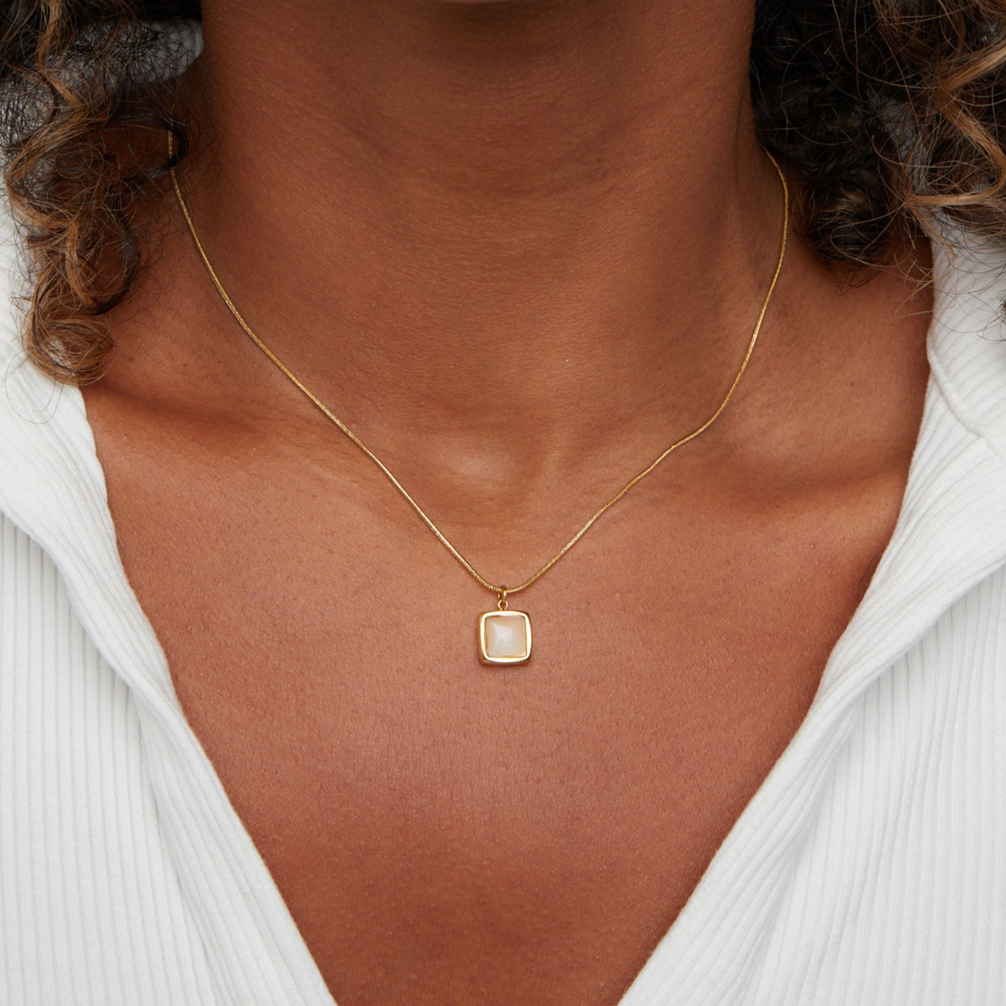 Riva Moonstone Pendant Necklace, worn on a neck with a white ribbed top, close-up on pendant