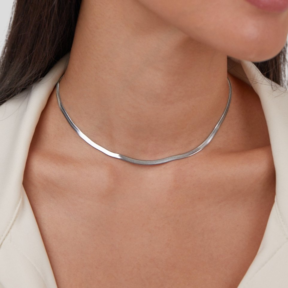 Sarya Snake Chain Silver Necklace, worn on a neck with a cream collar, close-up of silver chain