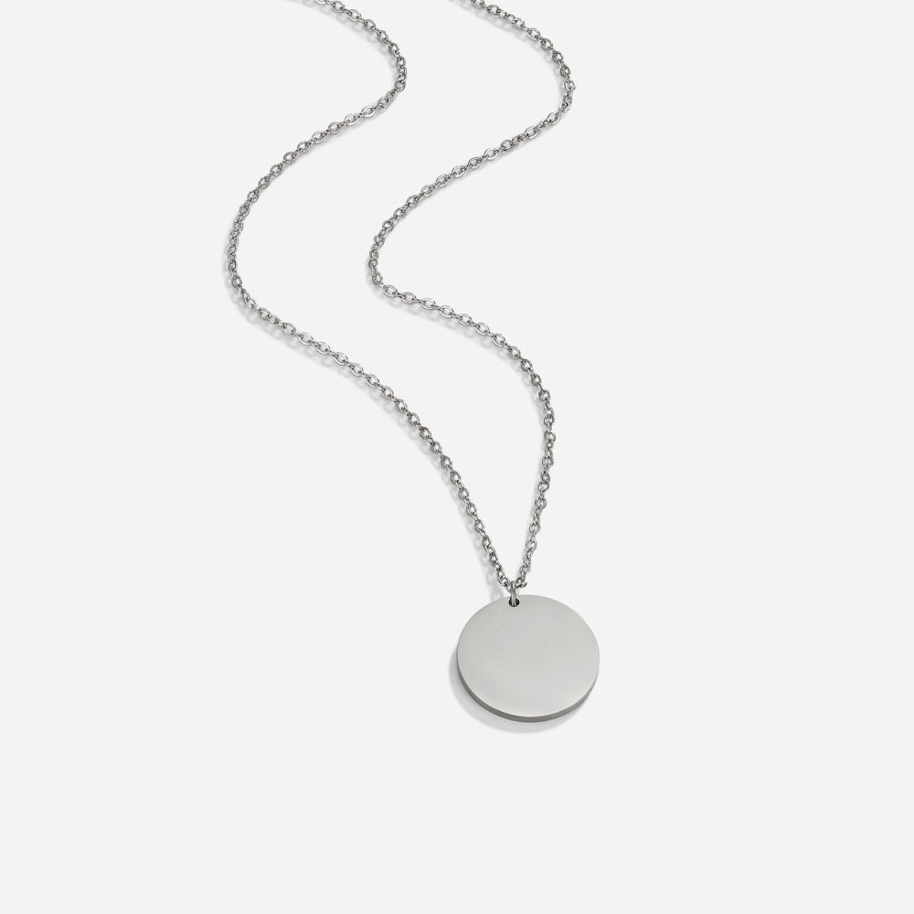 Silver Coin Necklace, flat-lay of a silver chain with a round disc pendant on white