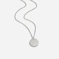 Silver Coin Necklace, flat-lay of a silver chain with a round disc pendant on white