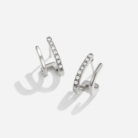 Silver & Crystal Claw Earrings, pair of silver earrings on white background, one with