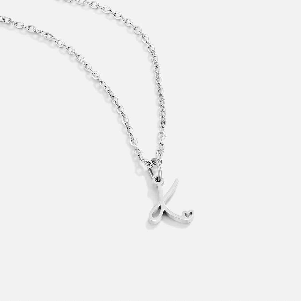 Silver Letter Heart Necklace, silver chain with a script letter K pendant on white