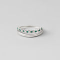 Silver Marissa Emerald Green Layered Ring, two silver bands stacked, one with a row of green stones, on grey