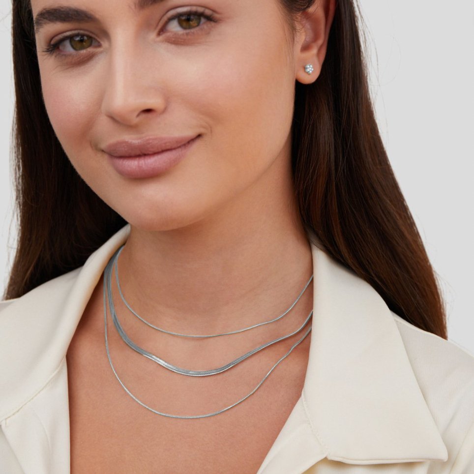 Silver Multi-Layered Chain Necklace, worn layered on a neck with a small stud earring