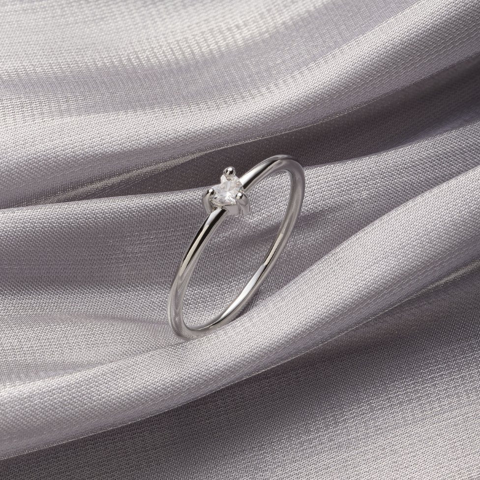 'Small Love' Crystal Heart Ring, thin silver ring with a small clear stone on grey silk fabric