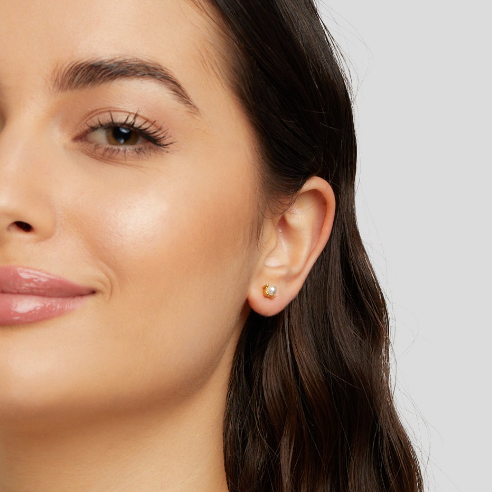 Free Sofia Pearl Stud Earrings, worn in an ear, close-up of a small gold stud with a pearl