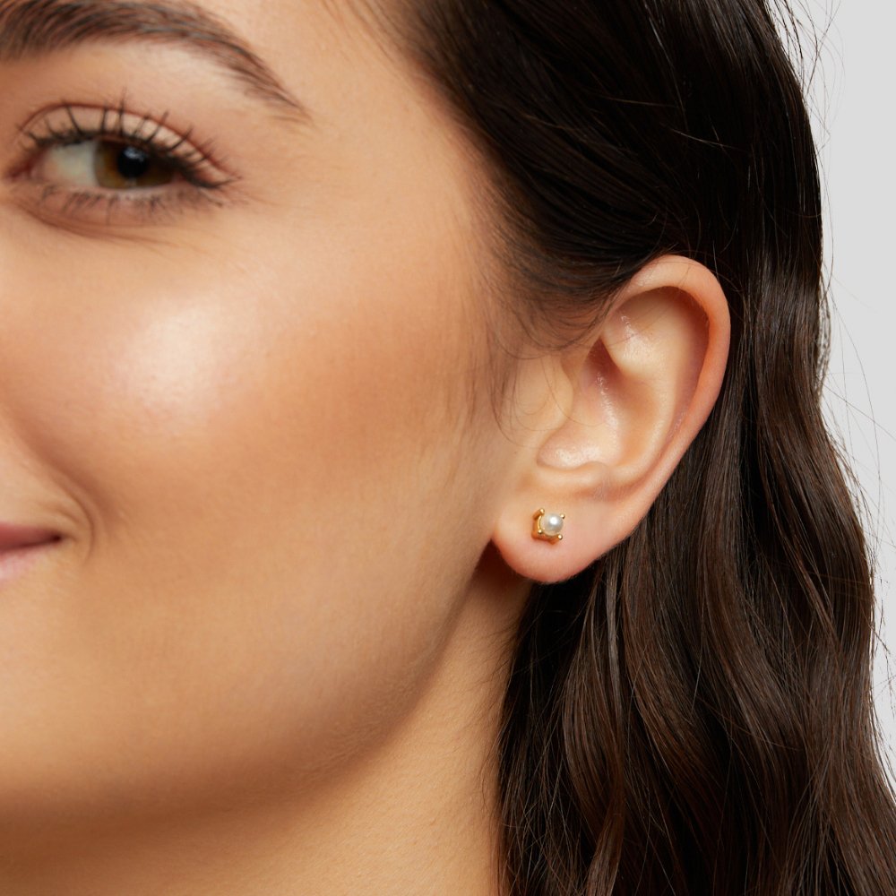 Free Sofia Pearl Stud Earrings, worn on an ear, small gold setting with a white pearl