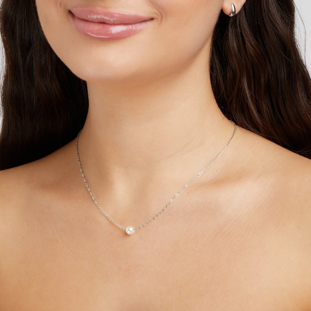 Solitaire Silver Pearl Necklace, worn on a model's neck, fine silver chain with a single pearl