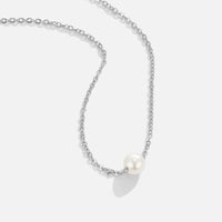 Solitaire Silver Pearl Necklace, silver chain necklace laid flat with a single white pearl