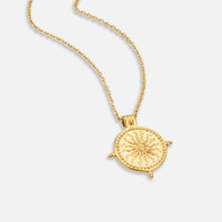 Summer Solstice Gold Necklace, gold necklace lying flat on white, round pendant with sun motif