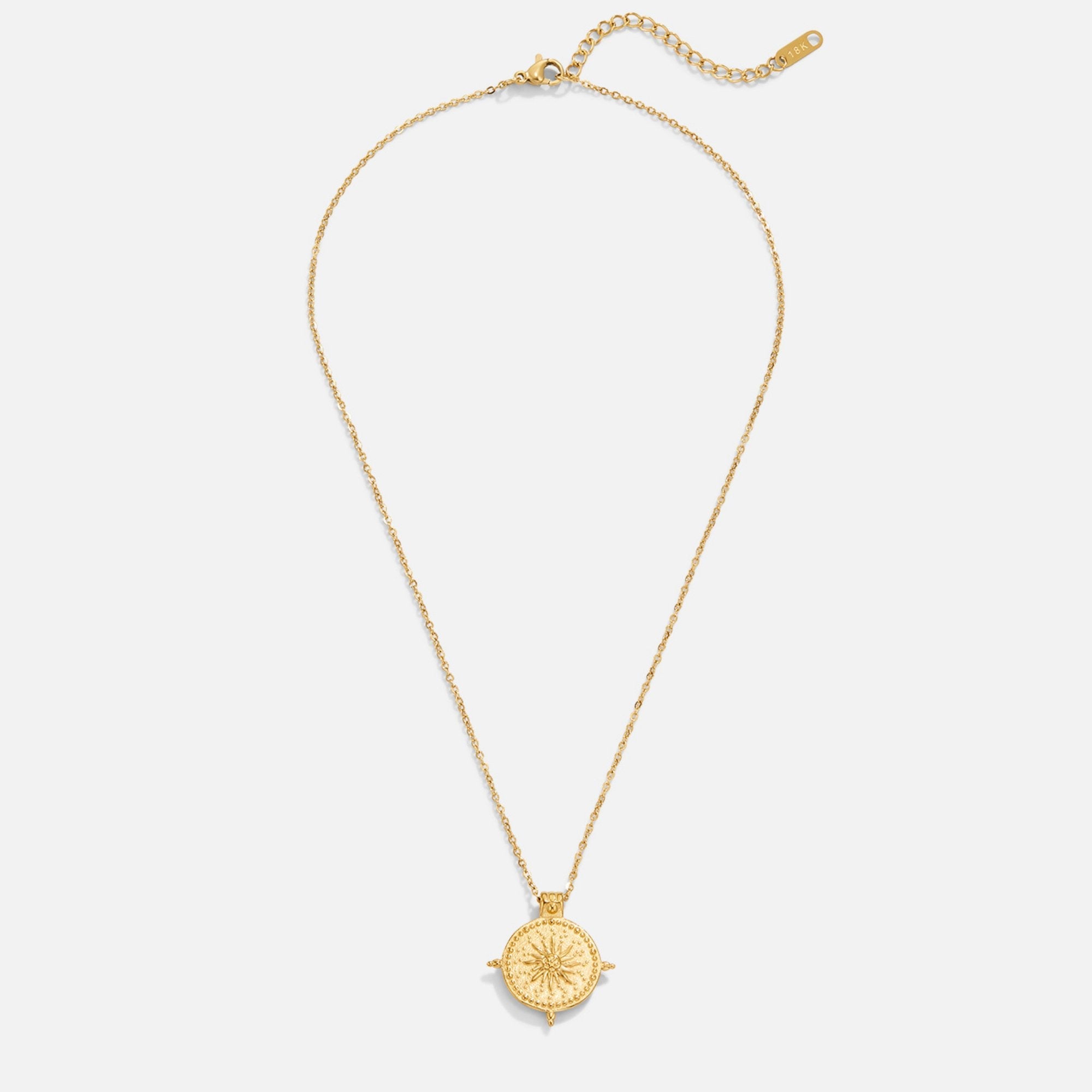 Summer Solstice Gold Necklace, flat lay of a gold chain with a round medallion and starburst design
