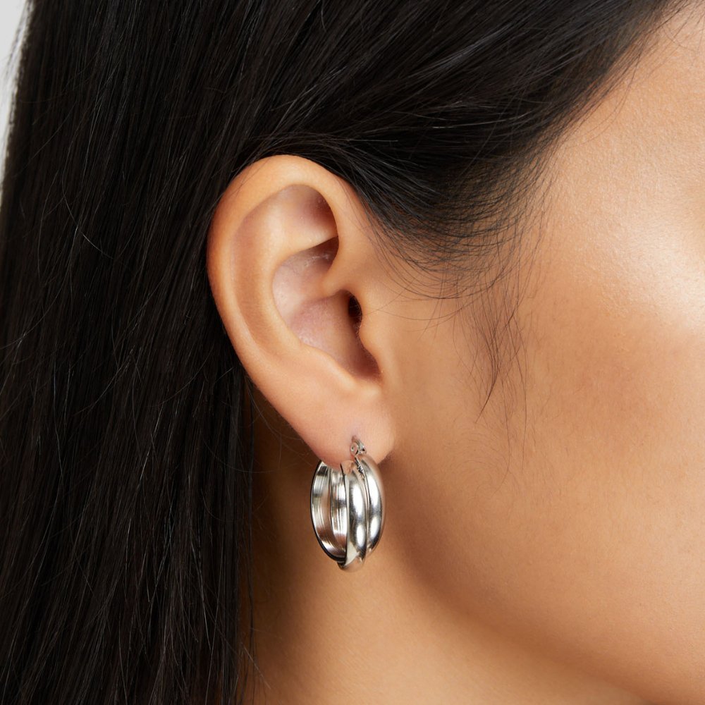 Talia Silver Hoop Earrings, worn on an ear, polished silver hoops with layered tubes