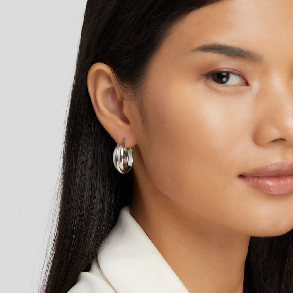 Talia Silver Hoop Earrings, worn on an ear, close-up of a chunky silver hoop