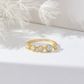 Tiffany Opal Stone Ring, gold band ring with five pale opal stones on white surface
