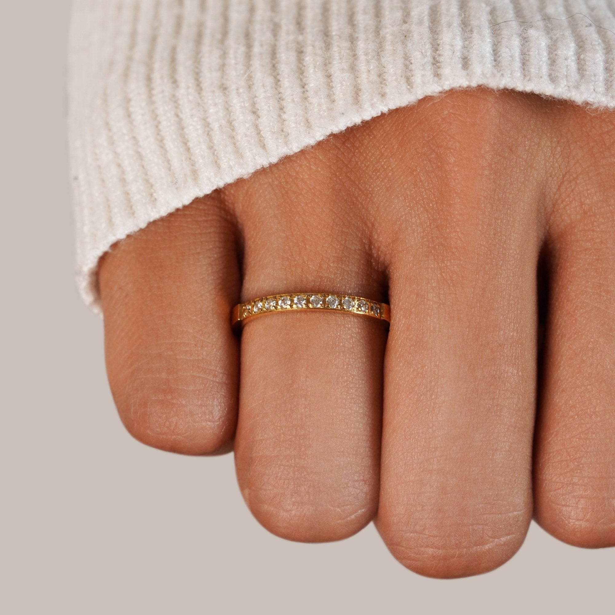 Timeless Beauty 18K Crystal Ring, worn on a finger with a cream knit sleeve, gold band with