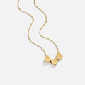 Trio Heart Pendant Necklace, gold chain necklace with three small heart charms on white background