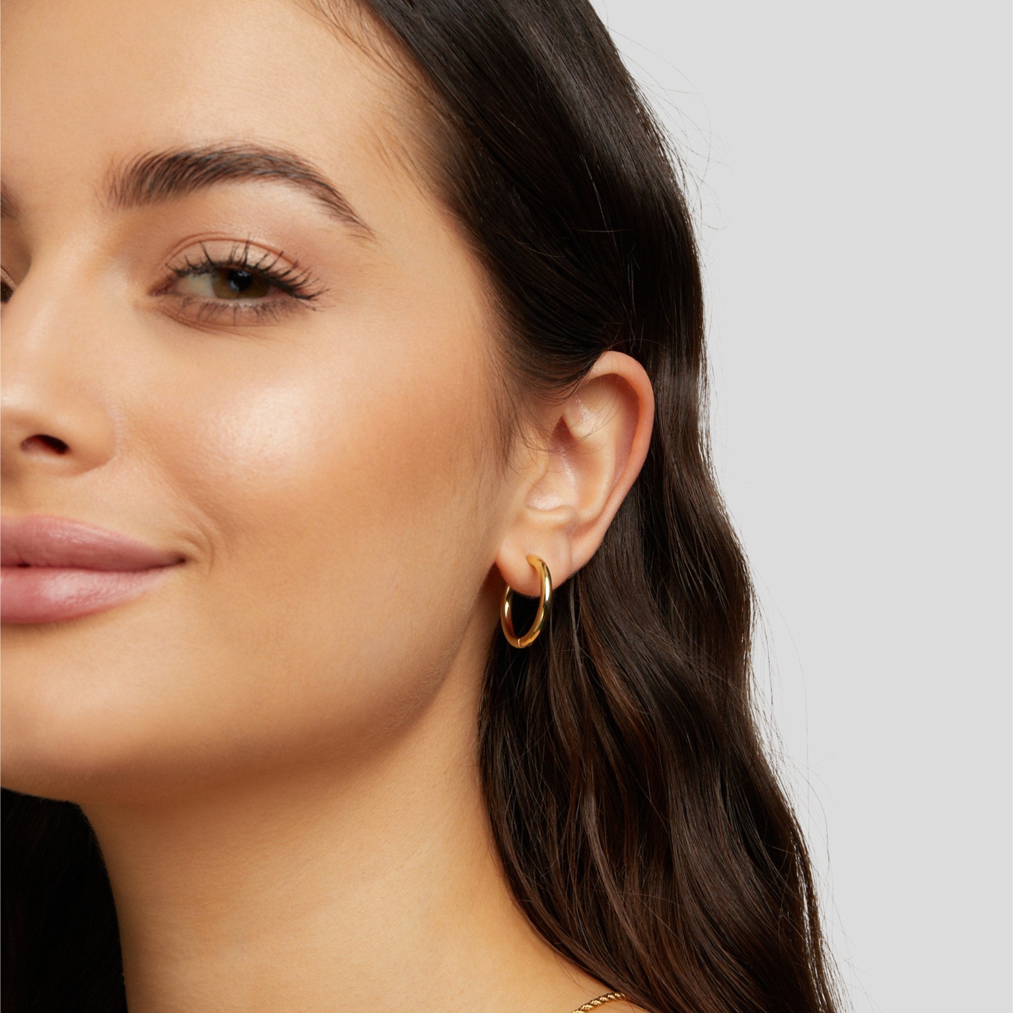 Triple Hoop Earrings Set, worn on an ear by a model with dark hair, gold hoop
