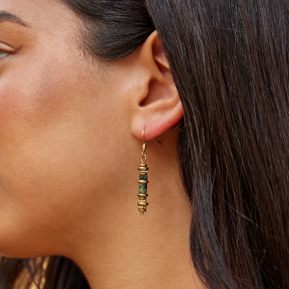 Turquoise Stone Drop Earrings, worn on an ear, gold beads with a green stone centre