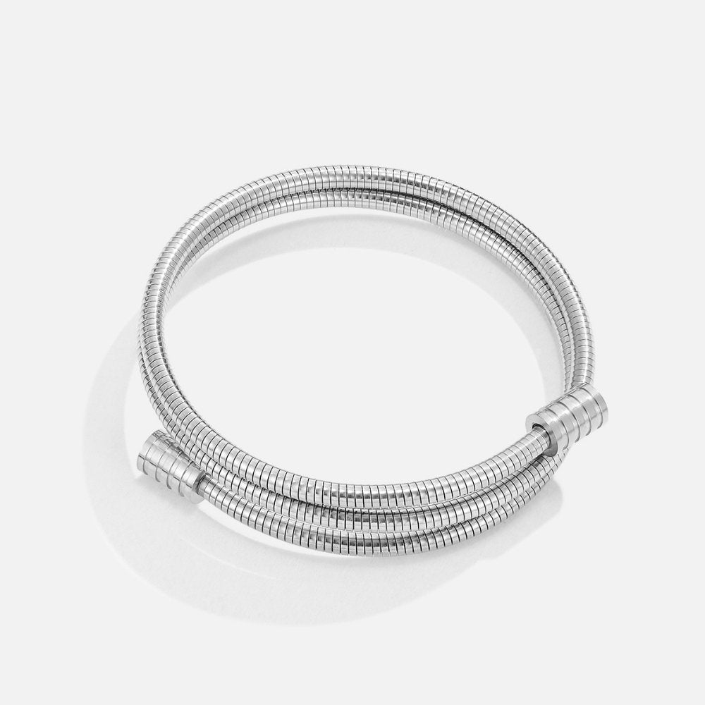 Twisted Silver Bracelet, two-strand silver bracelet lying flat on white, with ribbed end caps