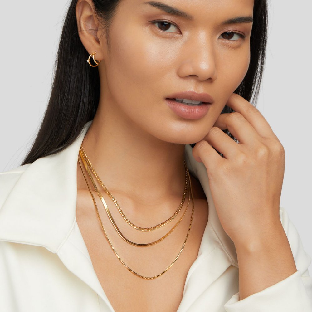 Vienna Layered Chain Necklace, worn layered at the neck over a white shirt, with a hoop earring