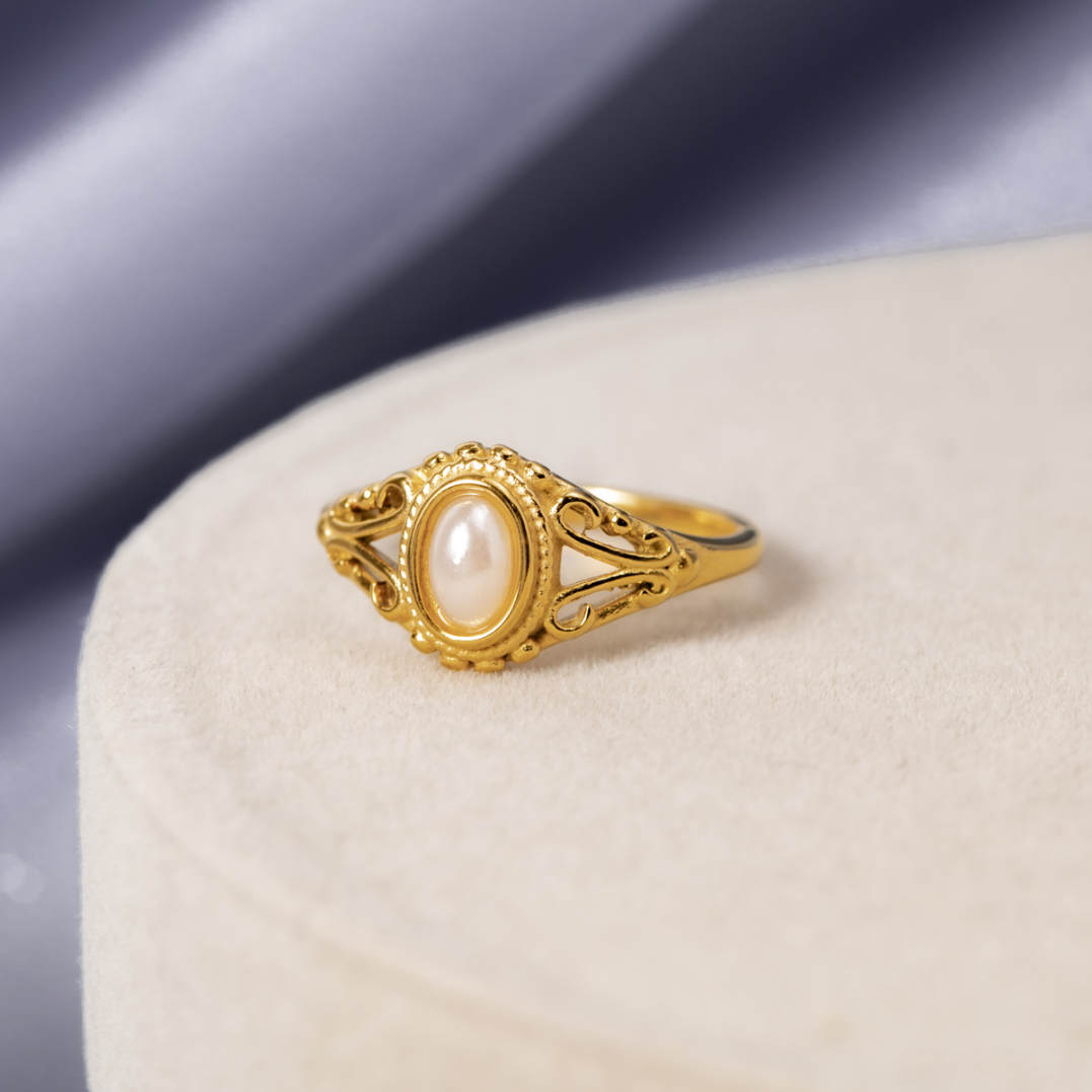 Vintage Royal Pearl Ring, gold ring with a pearl centre, displayed on a cream velvet block