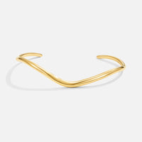 Wave Gold Bracelet, gold cuff bangle with a wavy shape, on a plain white background