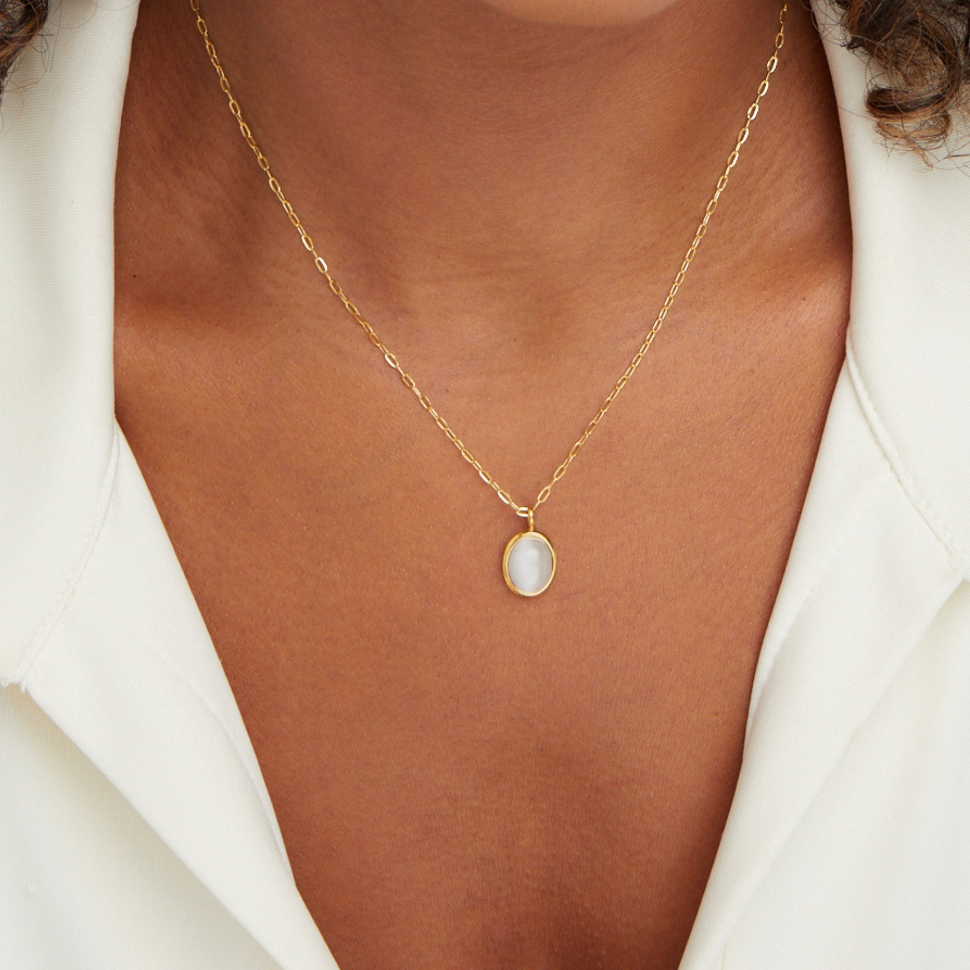 White Opal Necklace, worn on a neck with a white collared shirt, close-up on pale stone