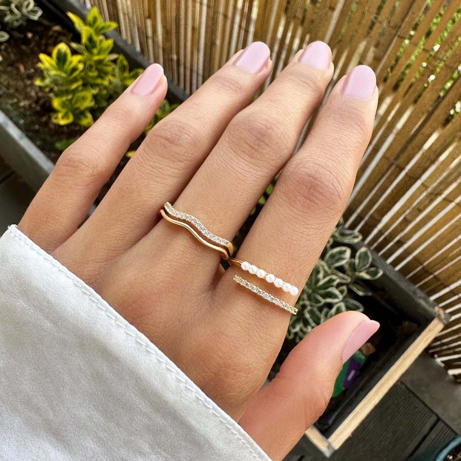 “Wrap Me” Pearl & Crystal Ring, worn on a hand with a wavy gold ring and a pearl ring